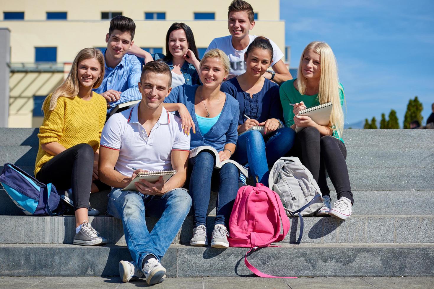 estudiantes afuera sentados en escalones foto