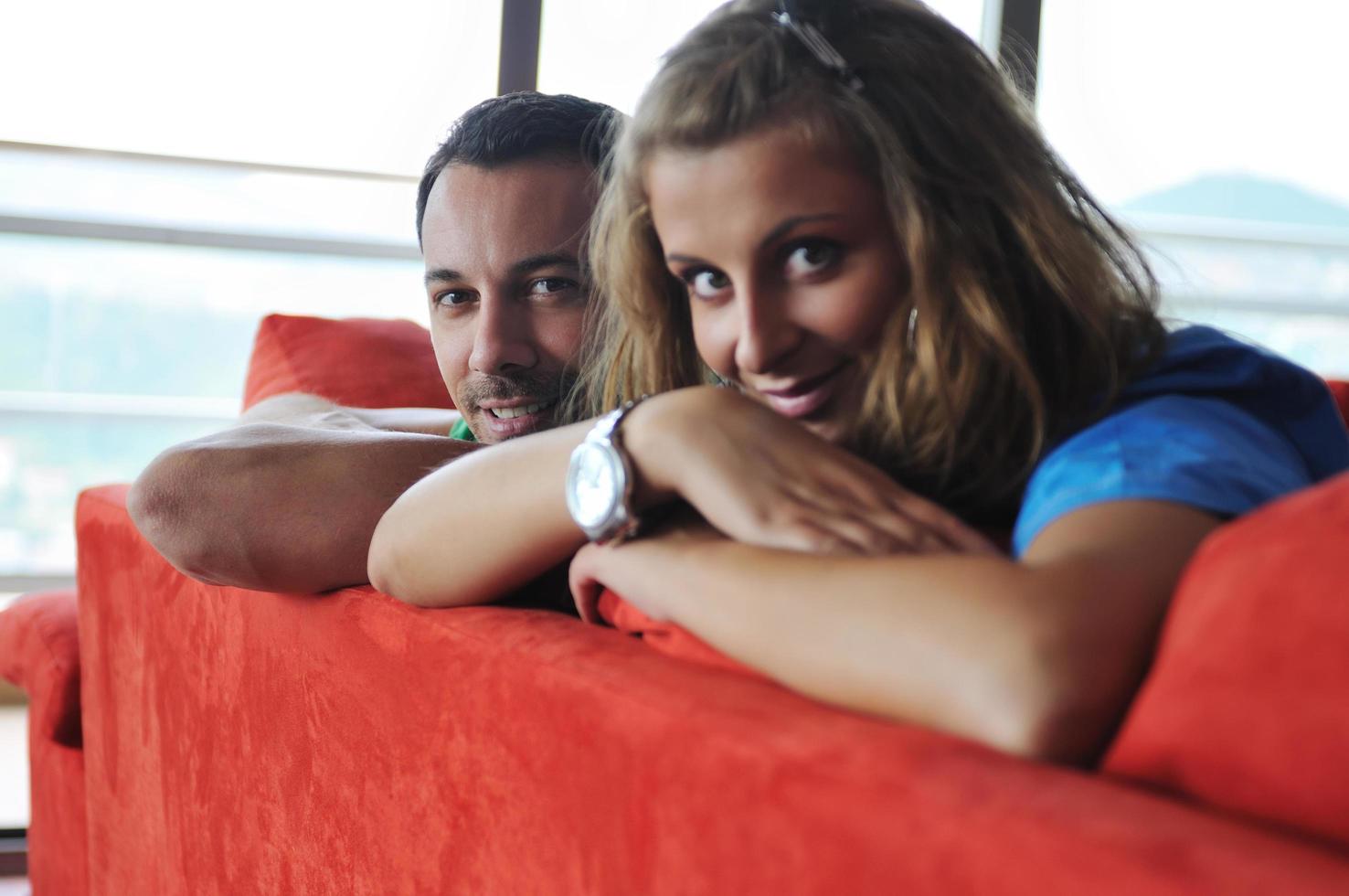 happy couple relax on red sofa photo