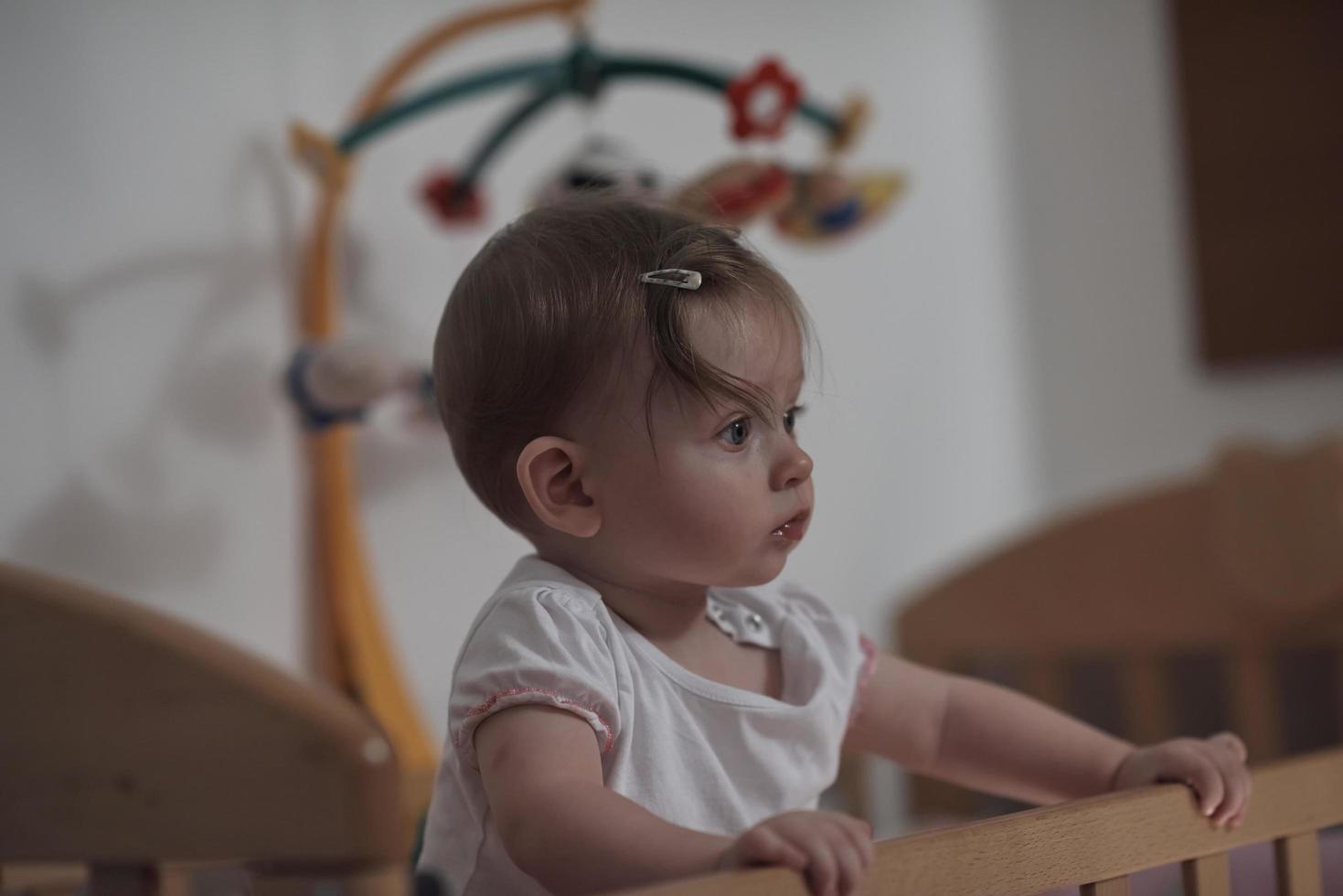 cute  little one year old baby and making first steps in bed photo