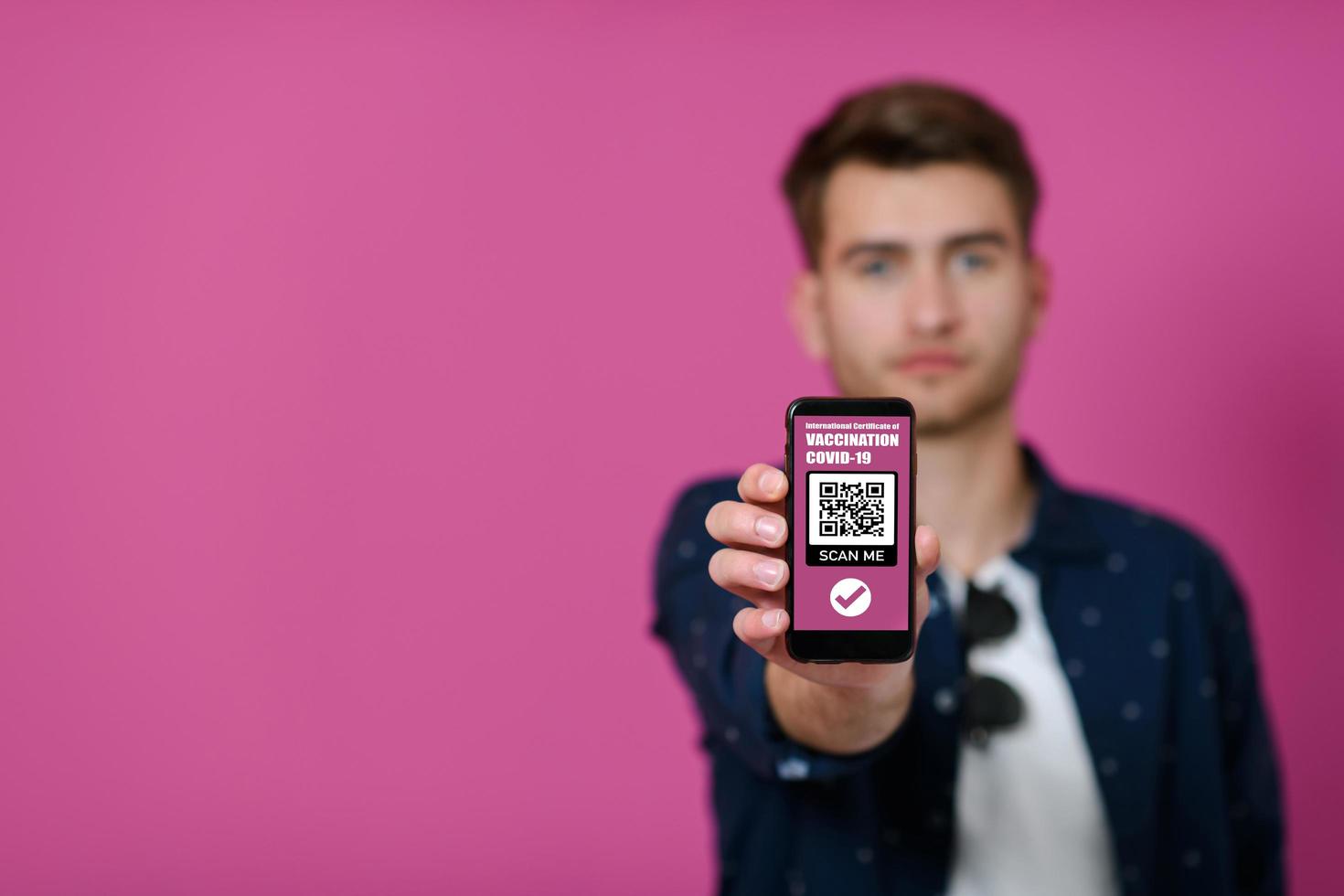 covid passport, a young man shows his code and covid passport on his cell phone photo