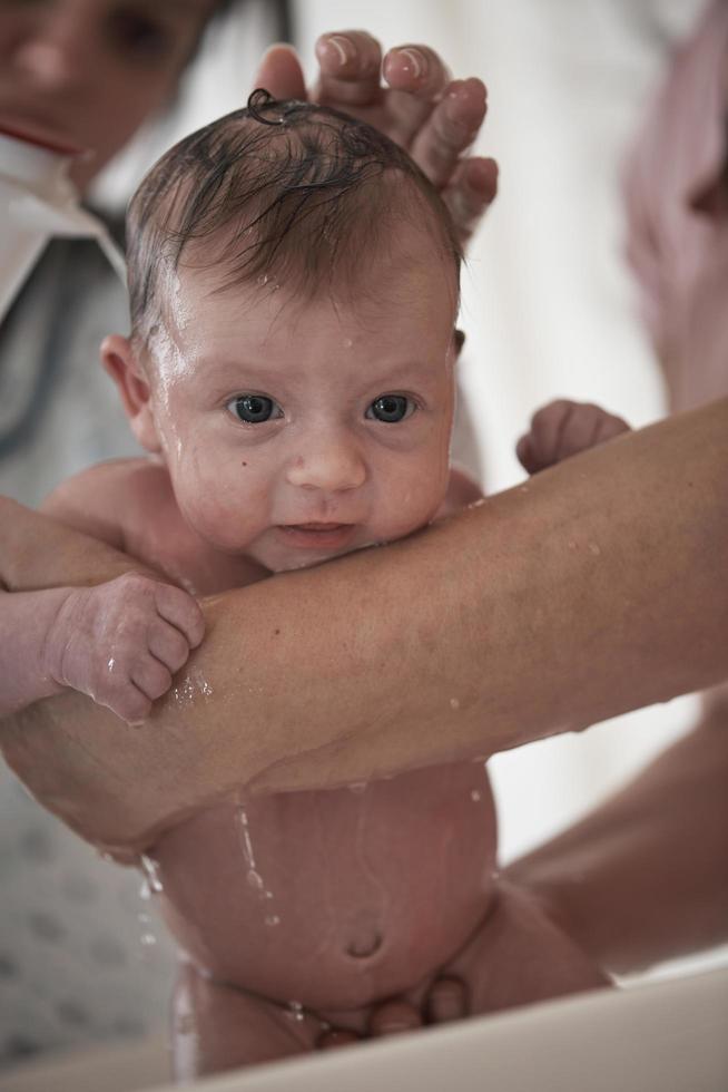 Newborn baby girl taking a  bath photo