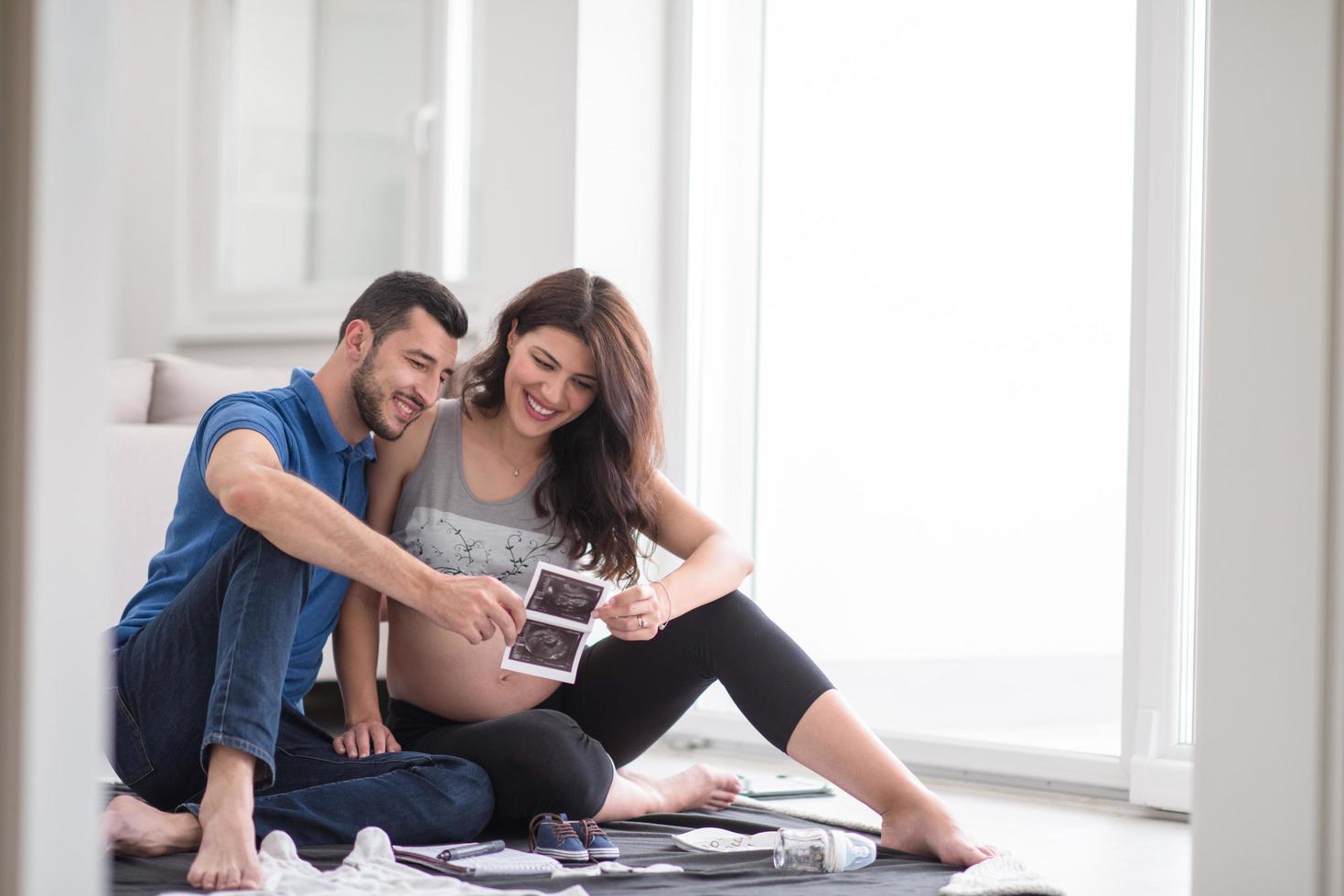 pregnant couple checking a list of things for their unborn baby photo