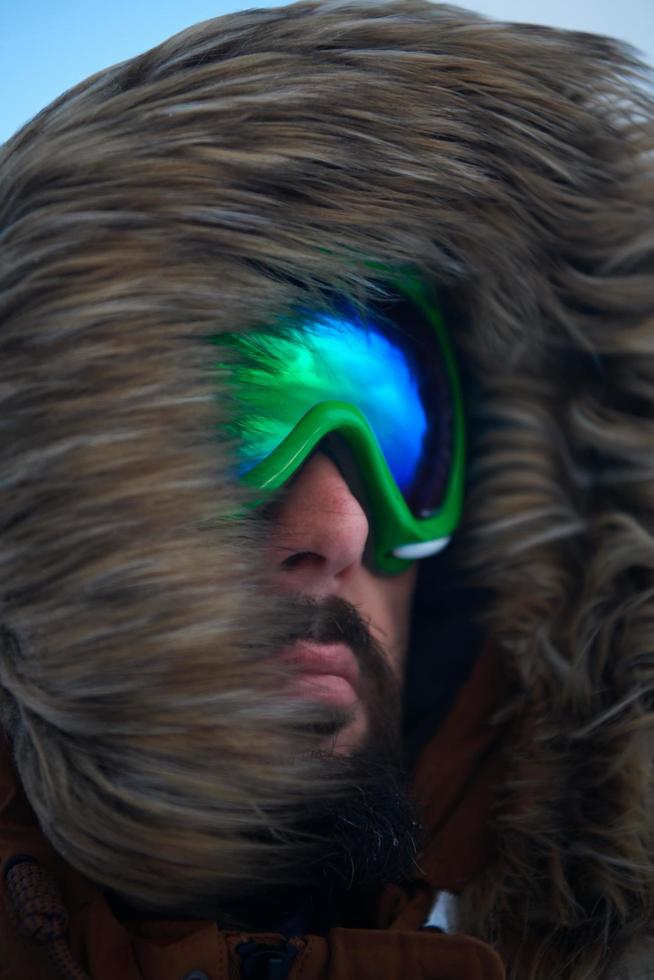 man at winter in stormy weather wearing warm  fur jacket photo