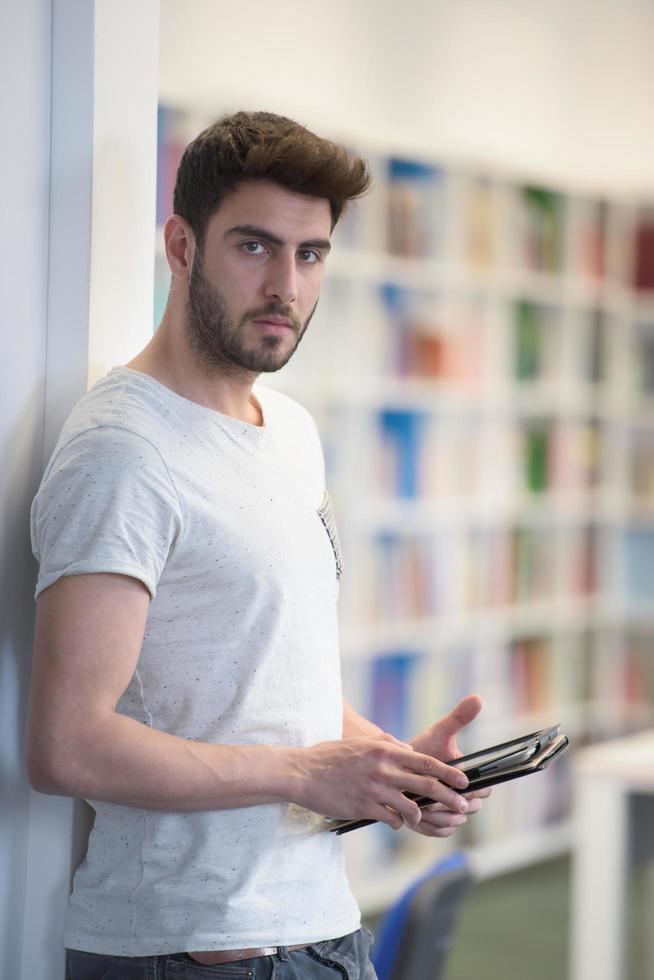 student in school library using tablet for research photo