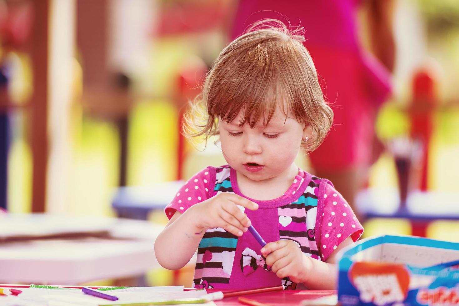 little girl drawing a colorful pictures photo