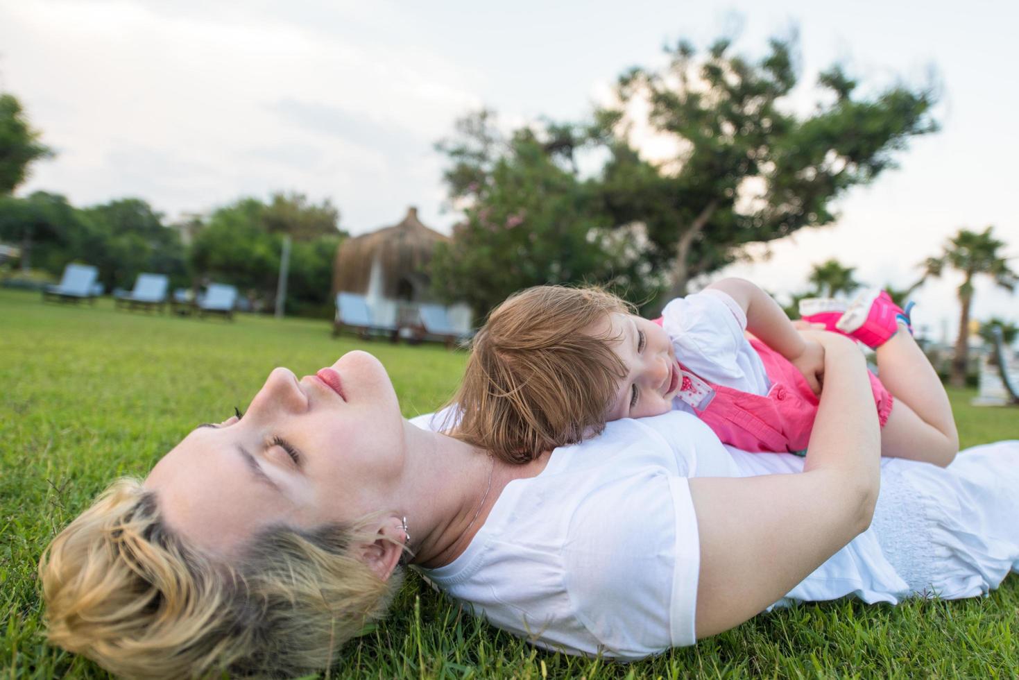 mother and little daughter playing at backyard photo