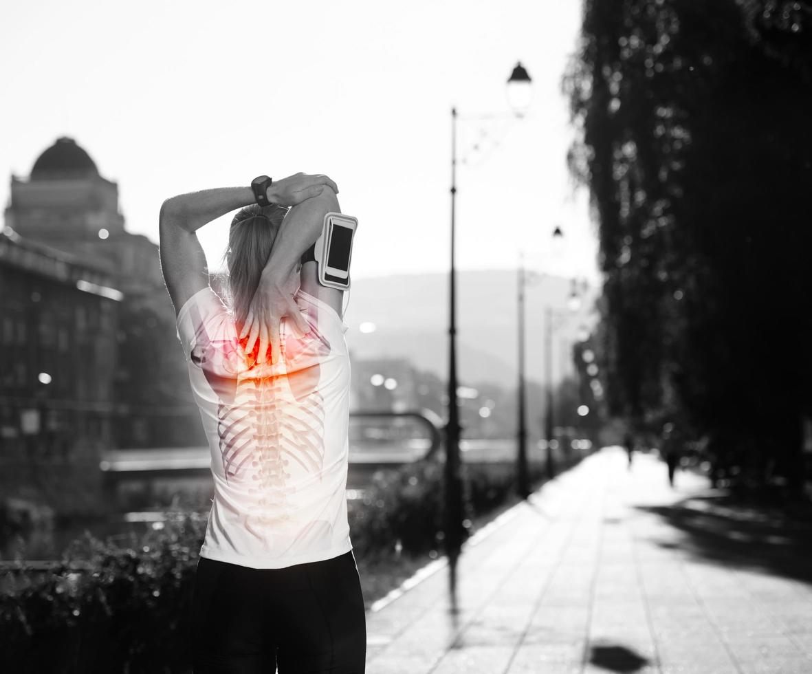 Jogging woman having pain in backbone and neck stretching photo