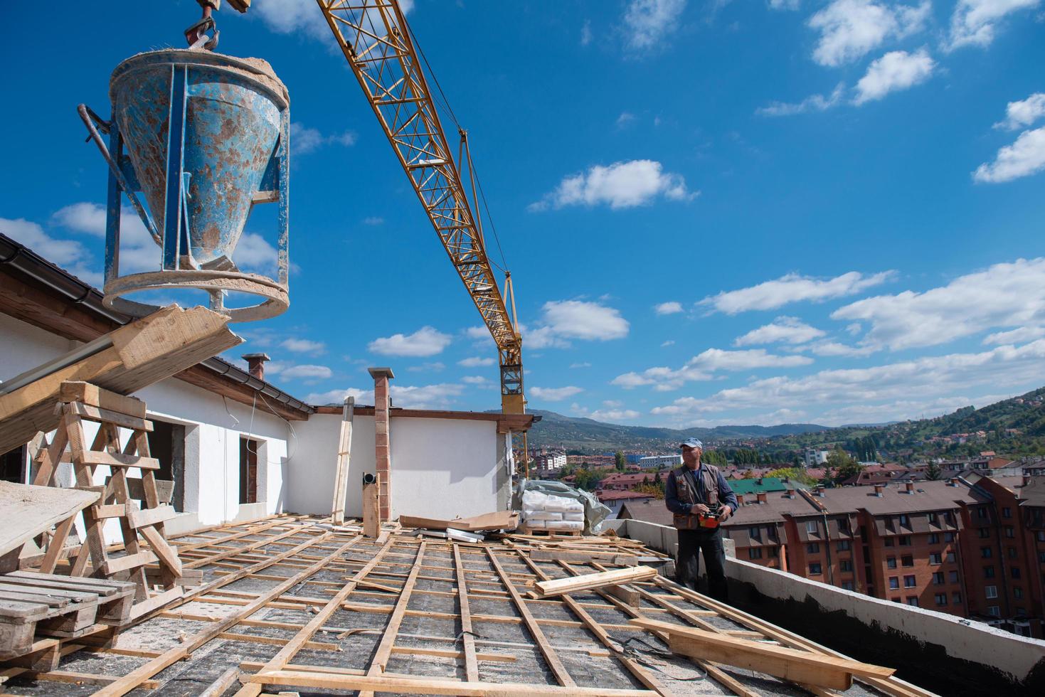 trabajador de techado con uniforme protector y guantes, herramientas para  techos, instalación de techos nuevos en construcción, taladro eléctrico  usado en techos nuevos con láminas de metal. 15632734 Foto de stock en