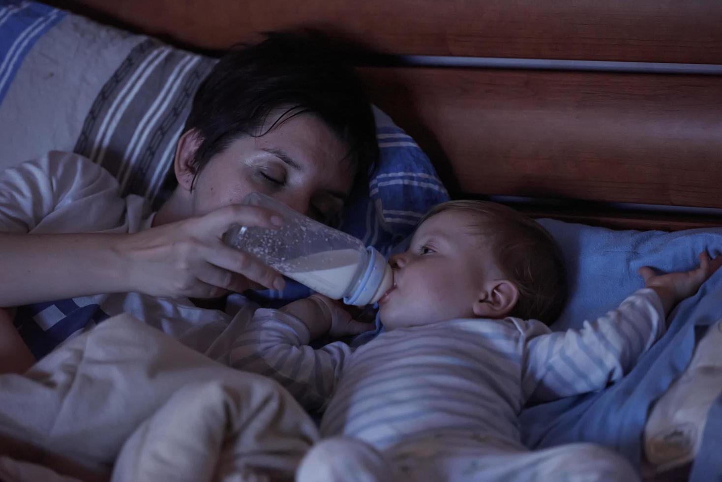 baby  eating milk from bottle photo