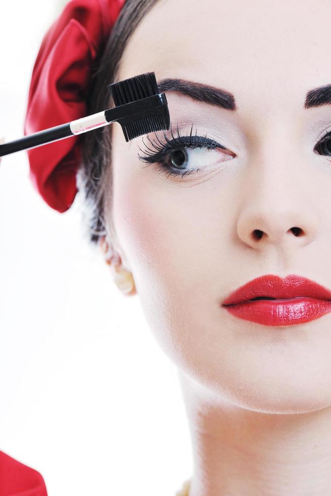 beautiful young woman applying makeup photo
