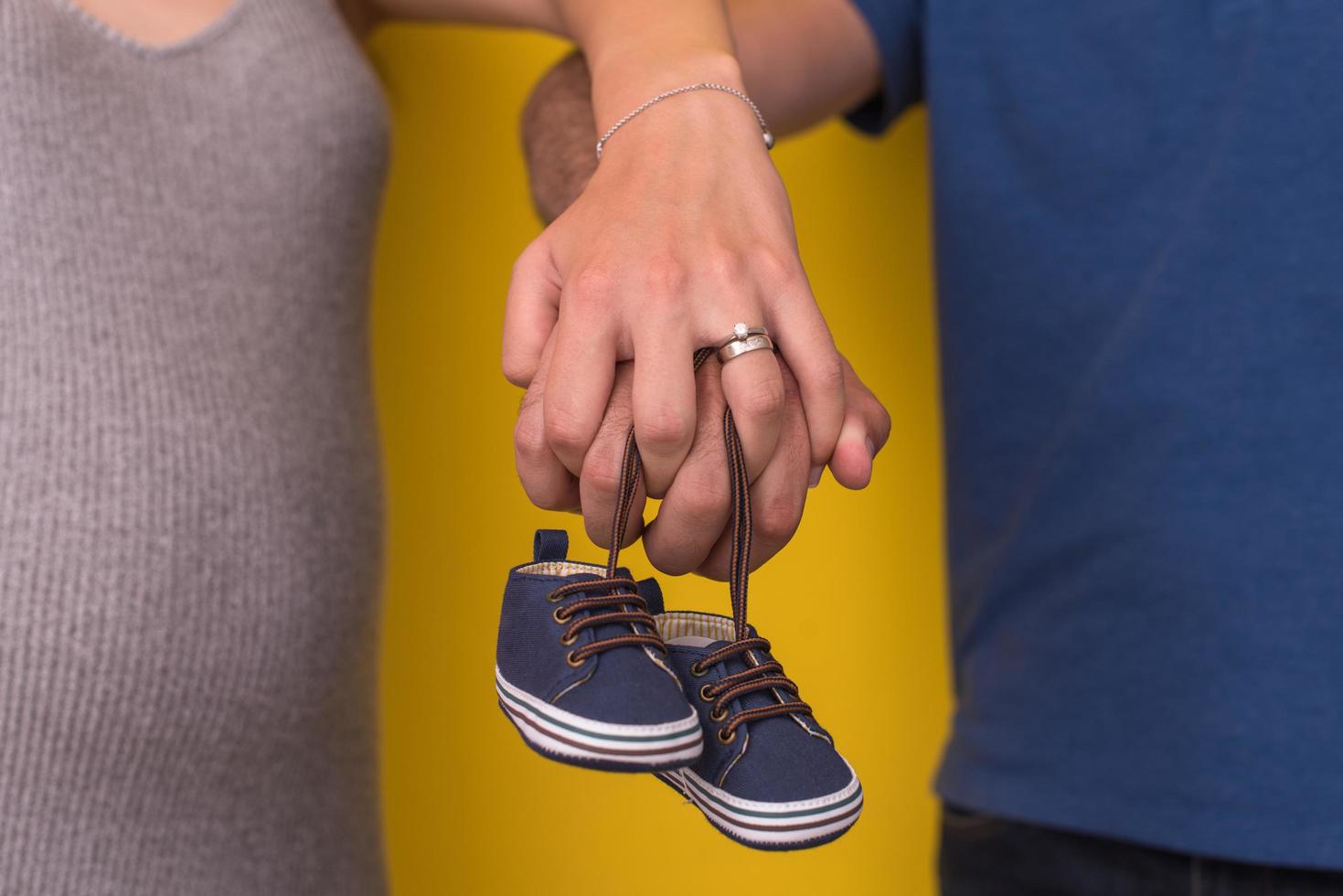 couple holding newborn baby shoes photo