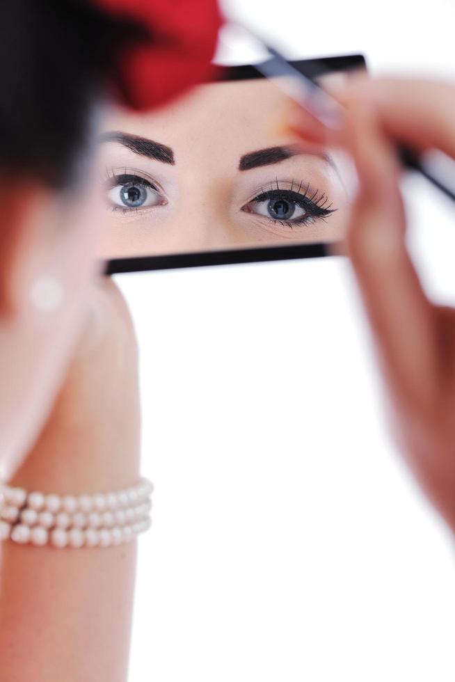 beautiful young woman applying makeup photo