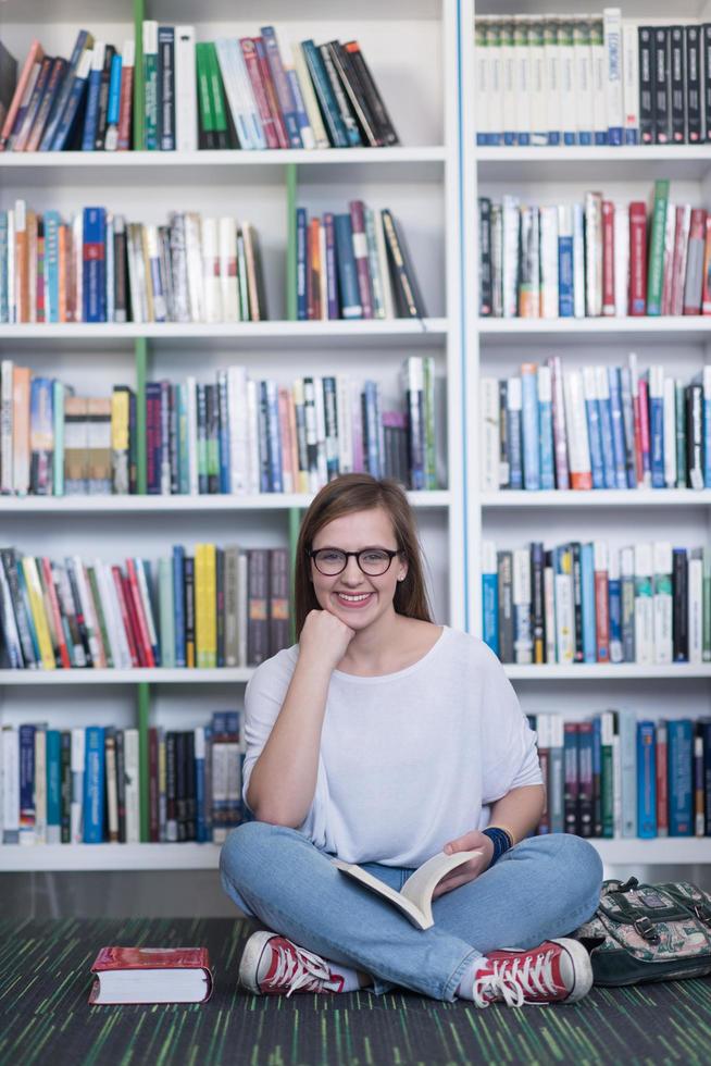 famale student reading book in library photo