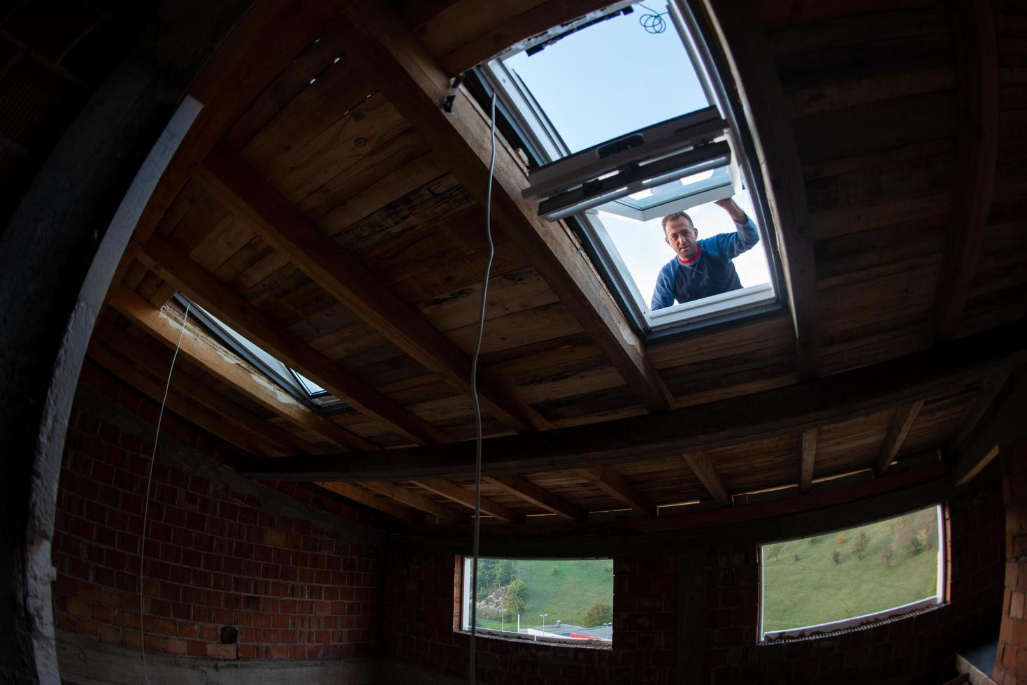 trabajador de la construcción instalando ventana de techo foto