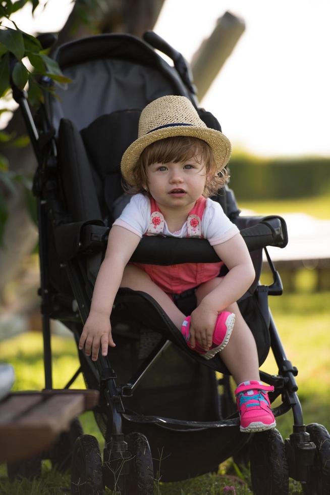 baby girl sitting in the baby stroller photo