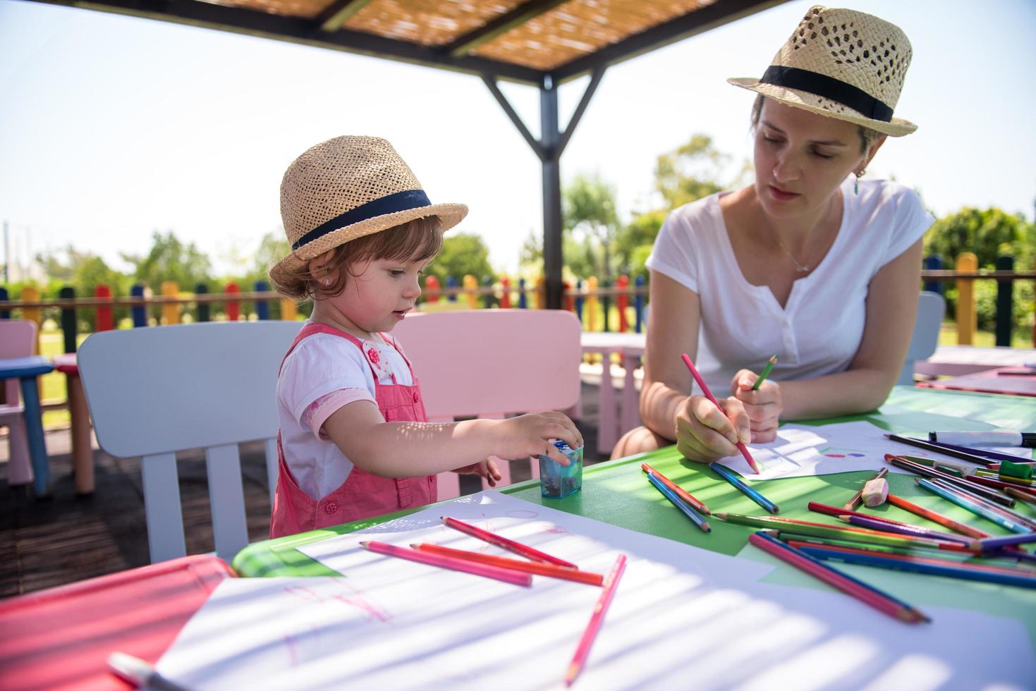 mom and little daughter drawing a colorful pictures photo