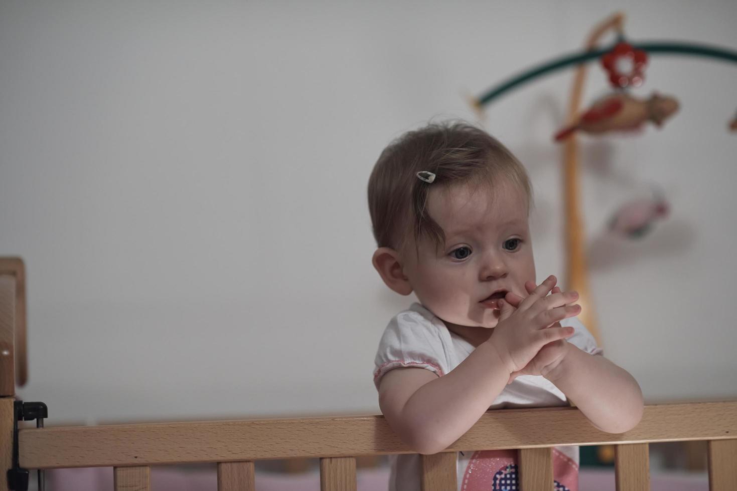 cute  little one year old baby and making first steps in bed photo