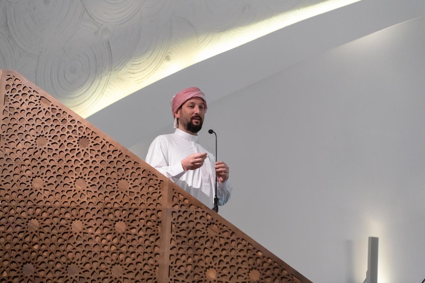 Muslims young arabic Imam has a speech on friday afternoon prayer in mosque. photo