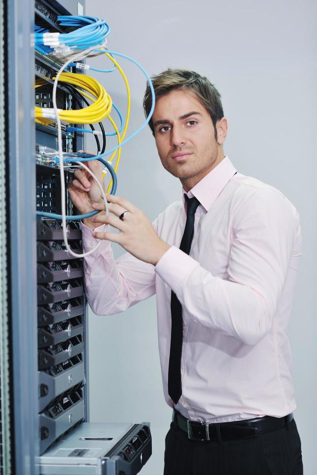 young it engineer in datacenter server room photo