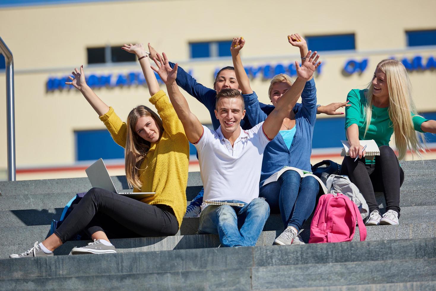 students outside sitting on steps photo