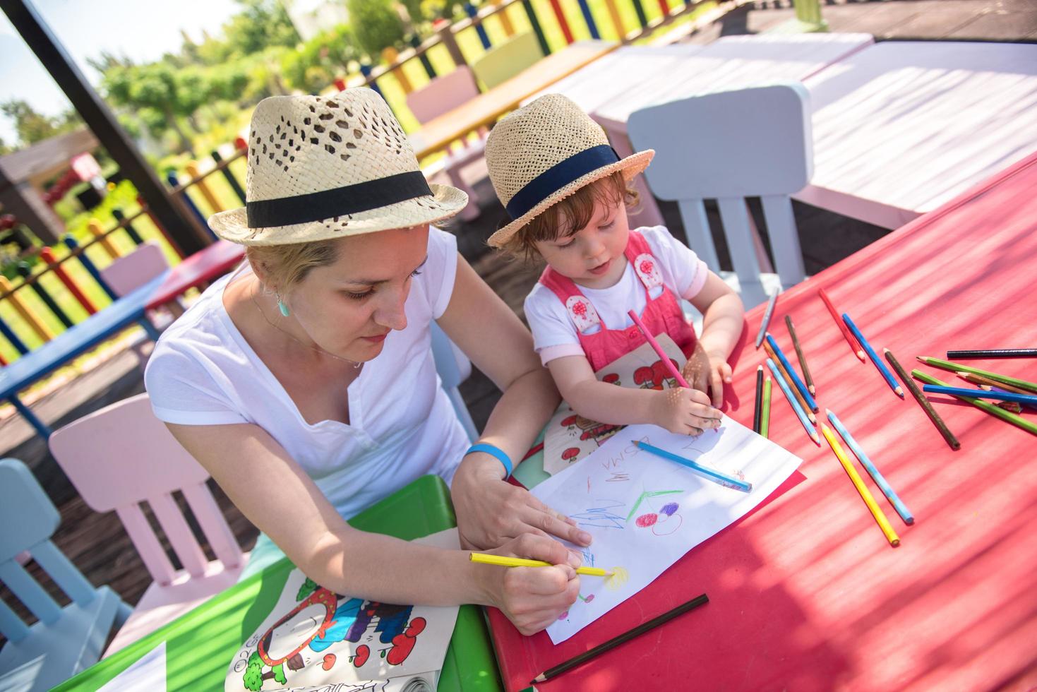 mamá y su pequeña hija dibujando imágenes coloridas foto