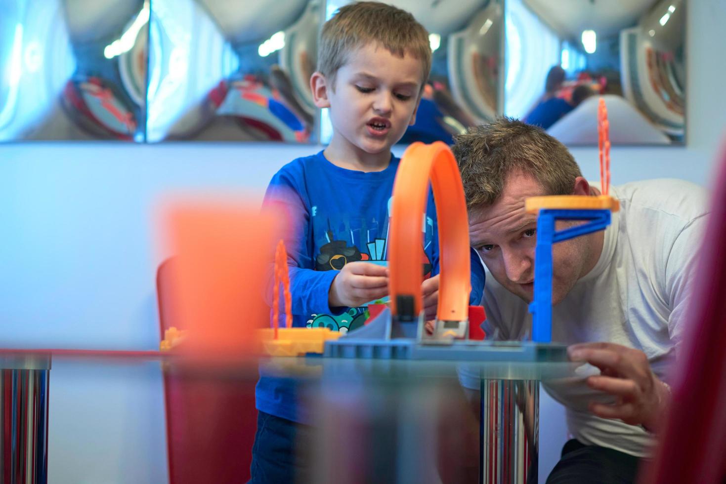 Father and children playing car toy game photo
