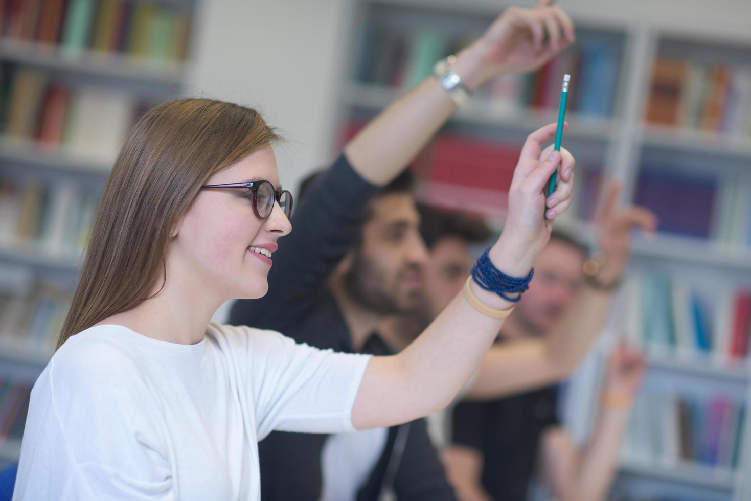 grupo de estudiantes levantan la mano foto