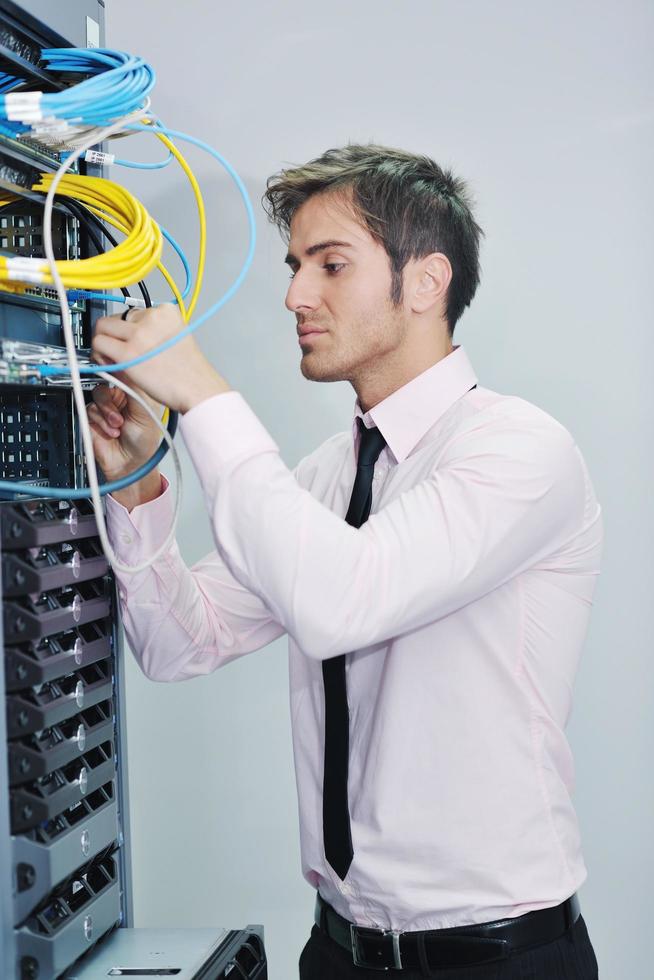 young it engineer in datacenter server room photo