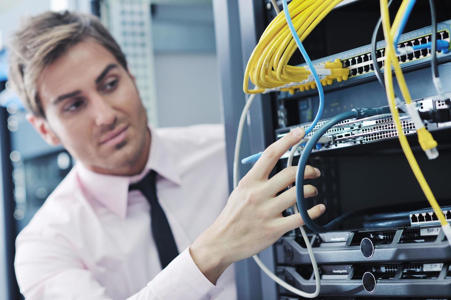 young it engineer in datacenter server room photo