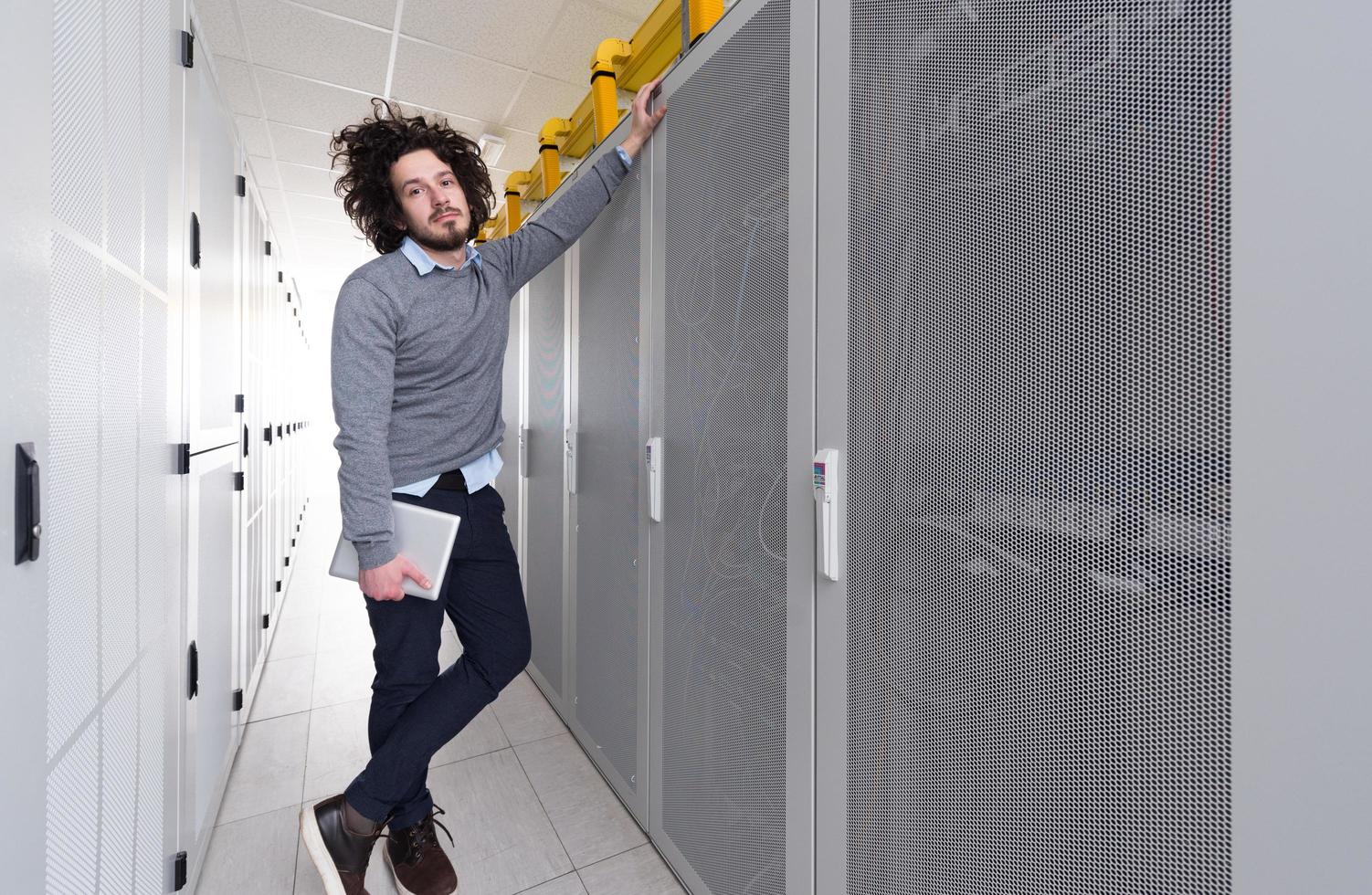 IT engineer working on a tablet computer in server room photo