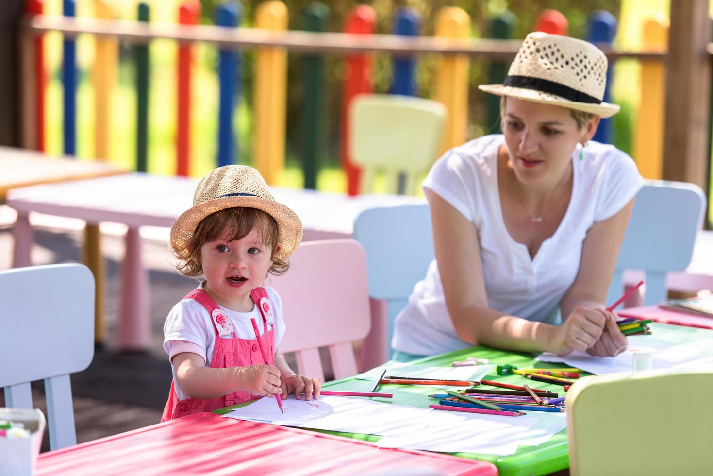 mamá y su pequeña hija dibujando imágenes coloridas foto