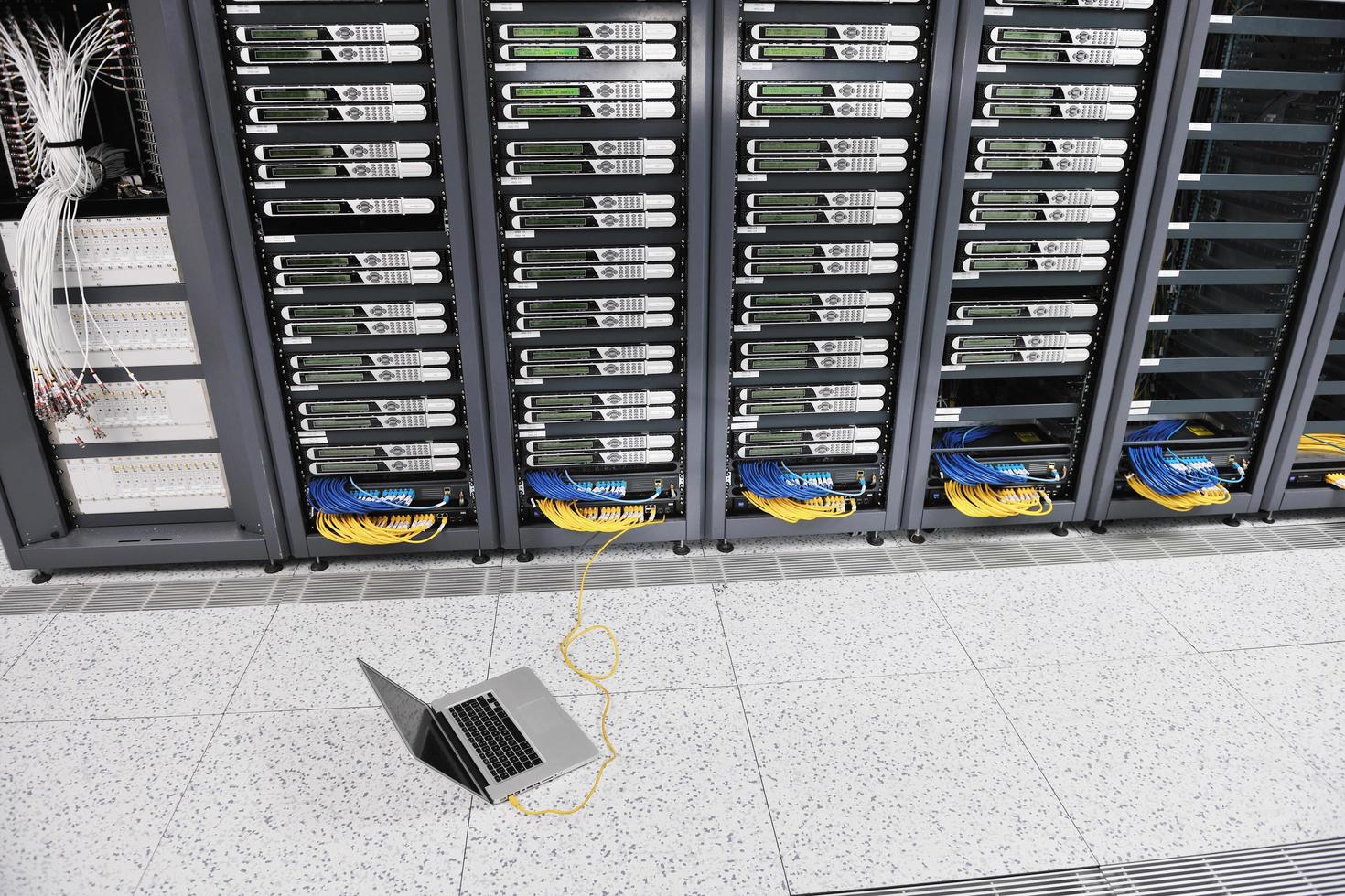 businessman with laptop in network server room photo