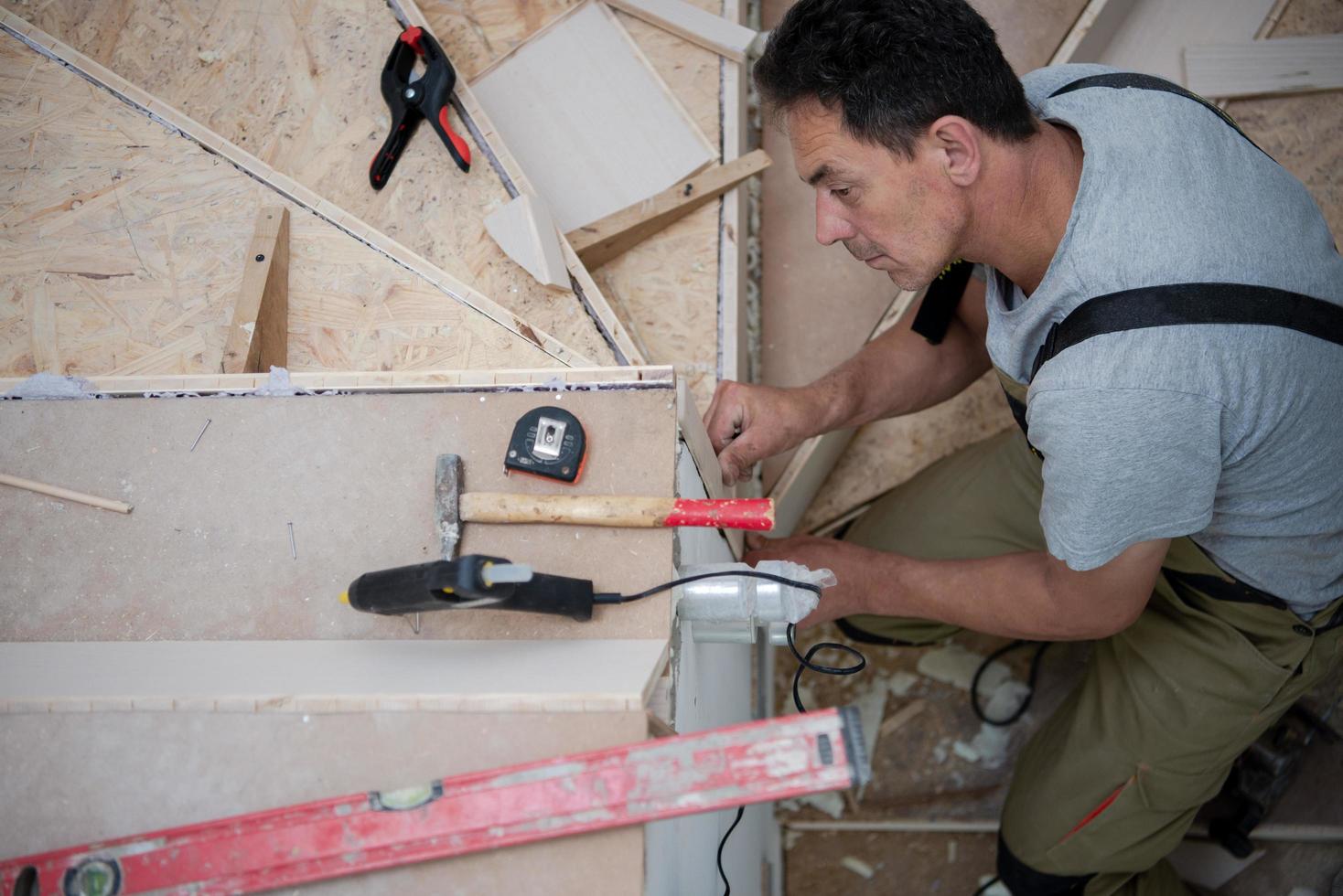 carpenter installing wooden stairs photo