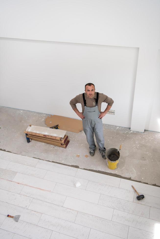 worker installing the ceramic wood effect tiles on the floor photo