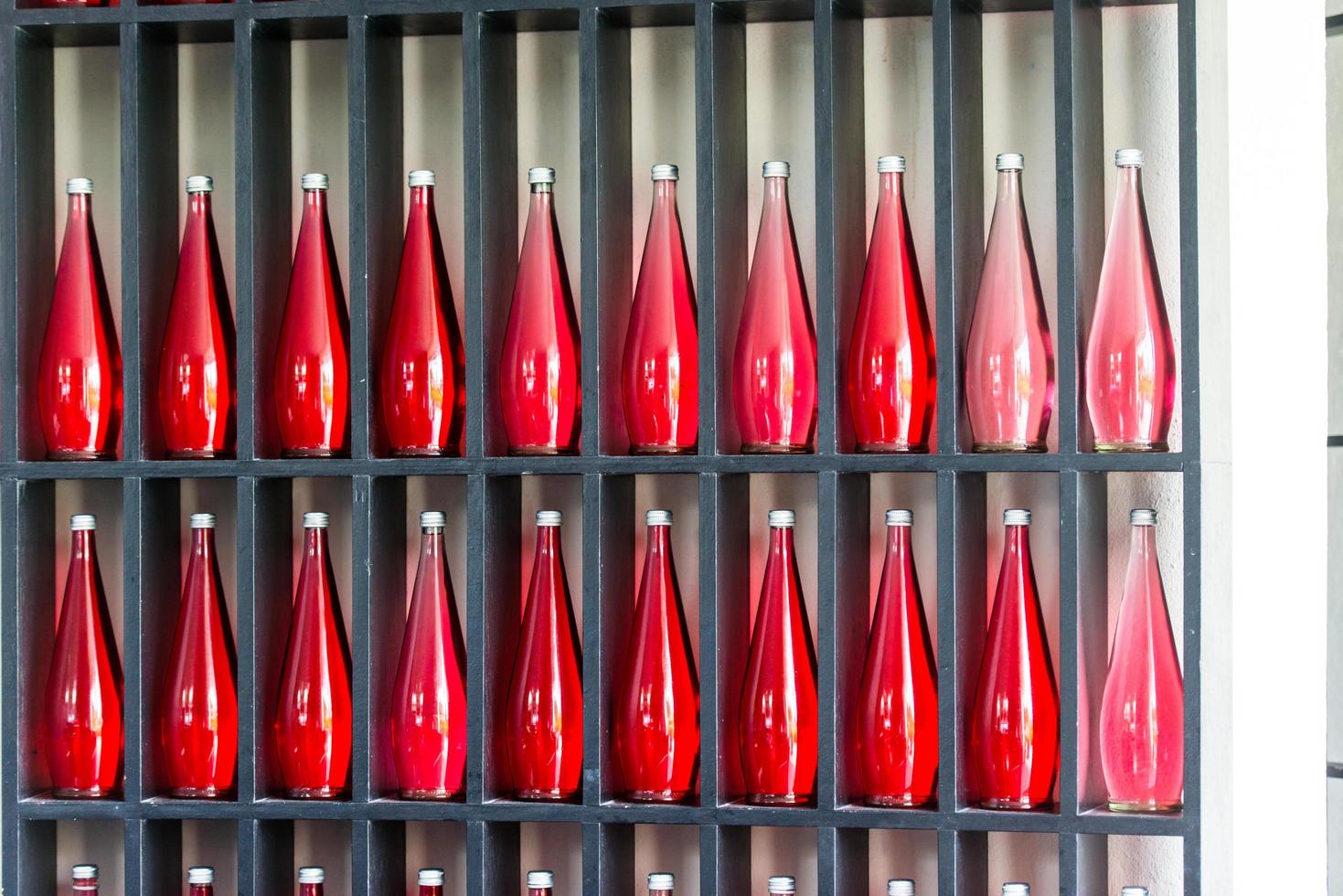 botellas de jugo rojo en un restaurante moderno foto