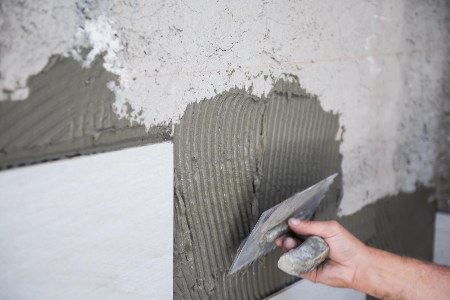 worker installing big ceramic tiles photo