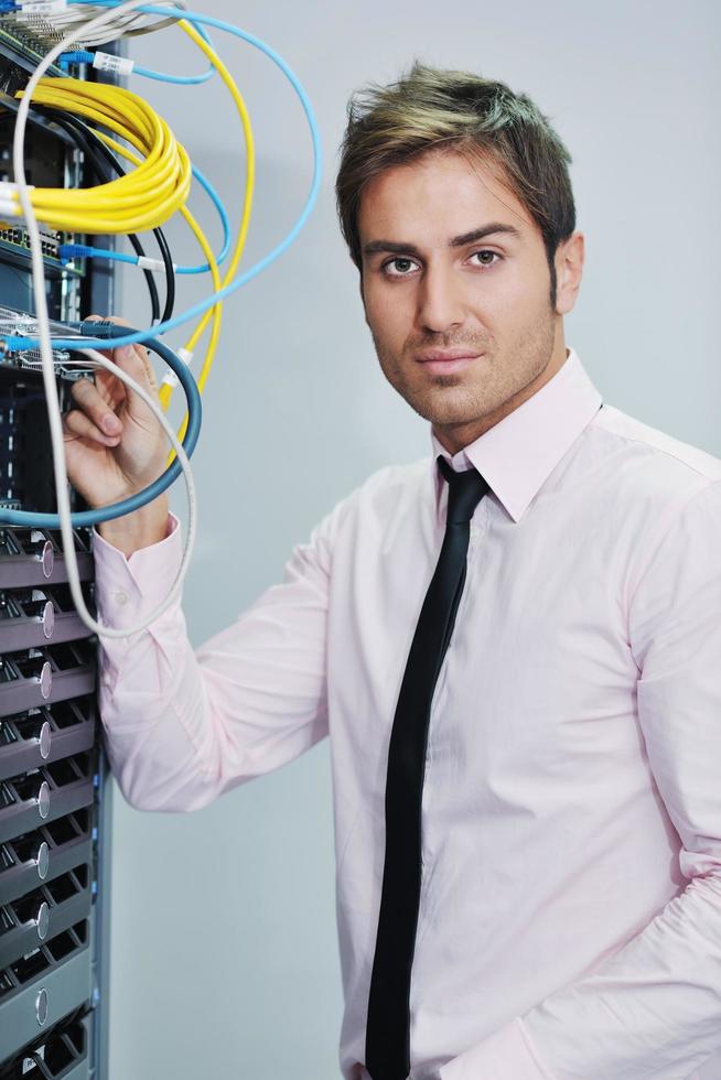 young it engineer in datacenter server room photo