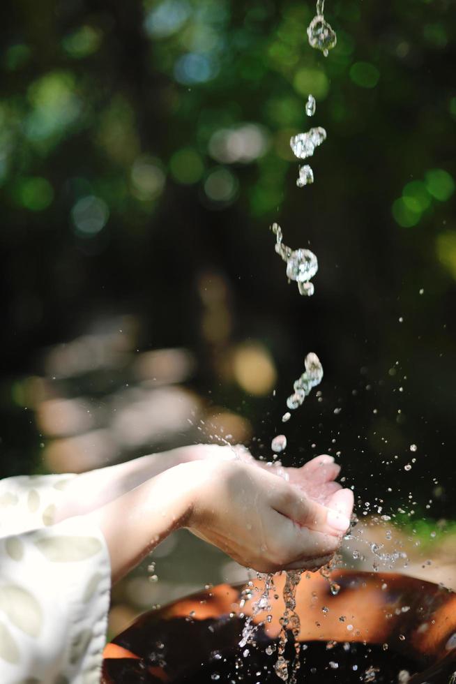 salpicando agua dulce en manos de mujer foto