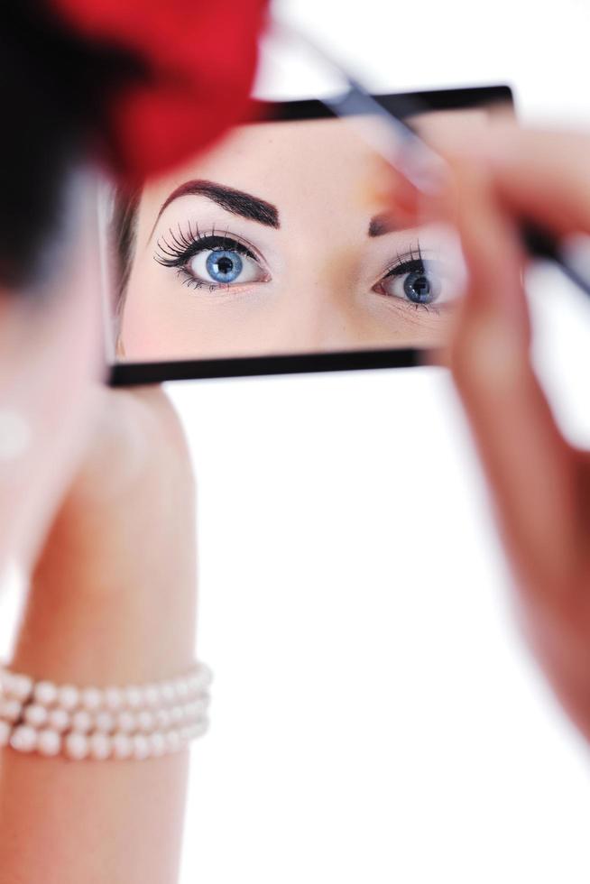 beautiful young woman applying makeup photo