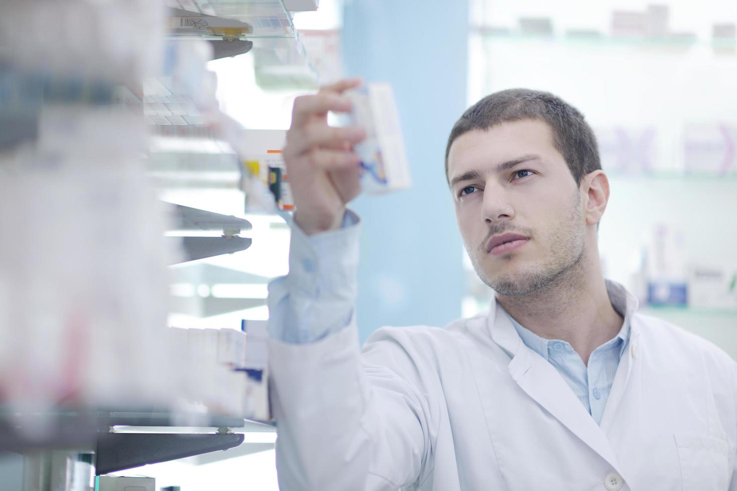 pharmacist chemist man in pharmacy drugstore photo