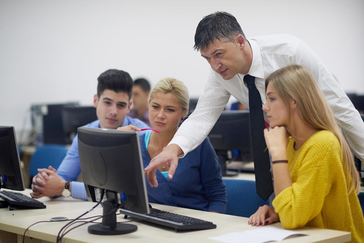 students with teacher  in computer lab classrom photo