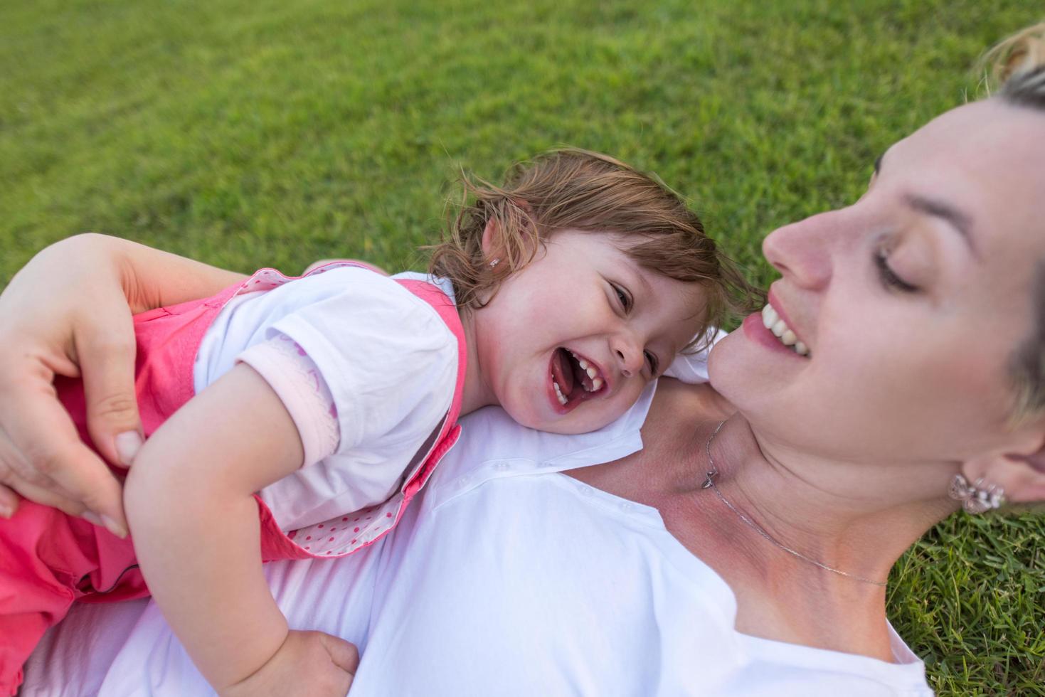 mother and little daughter playing at backyard photo