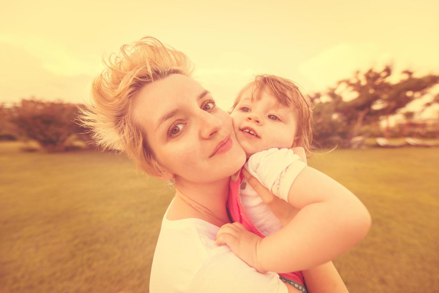 mother and little daughter playing at backyard photo