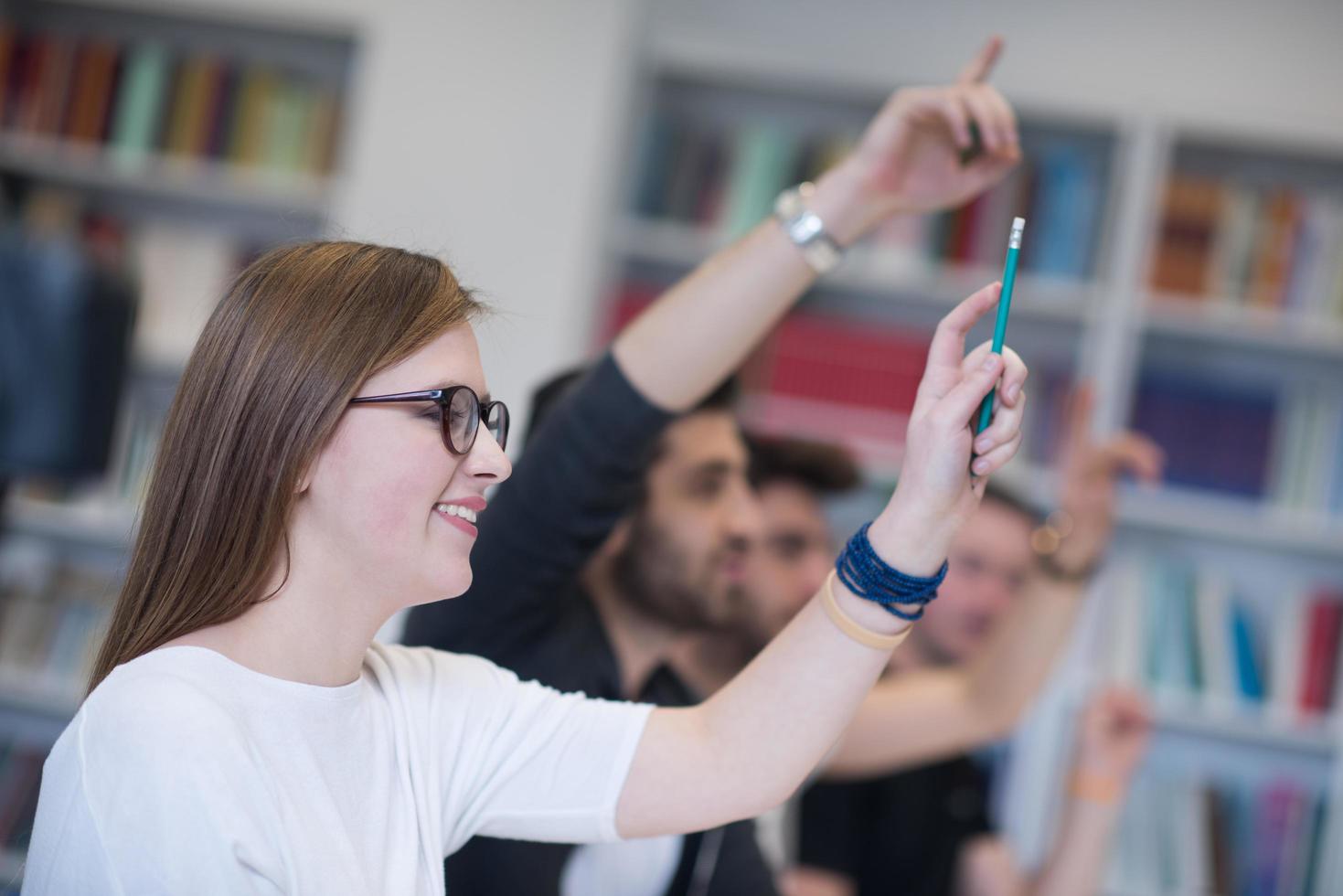 grupo de estudiantes levantan la mano foto