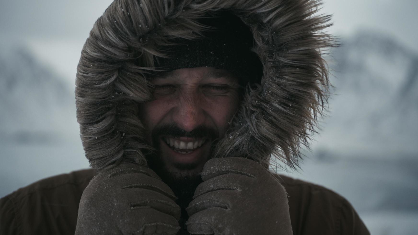 man at winter in stormy weather wearing warm  fur jacket photo