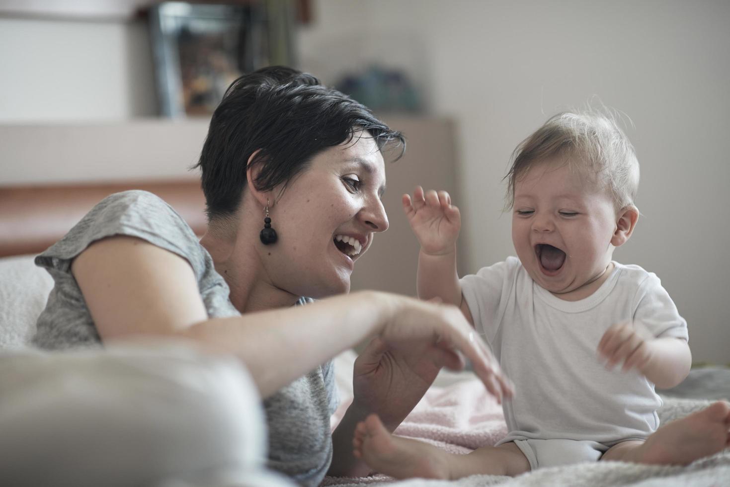 la madre está jugando con el bebé en casa foto