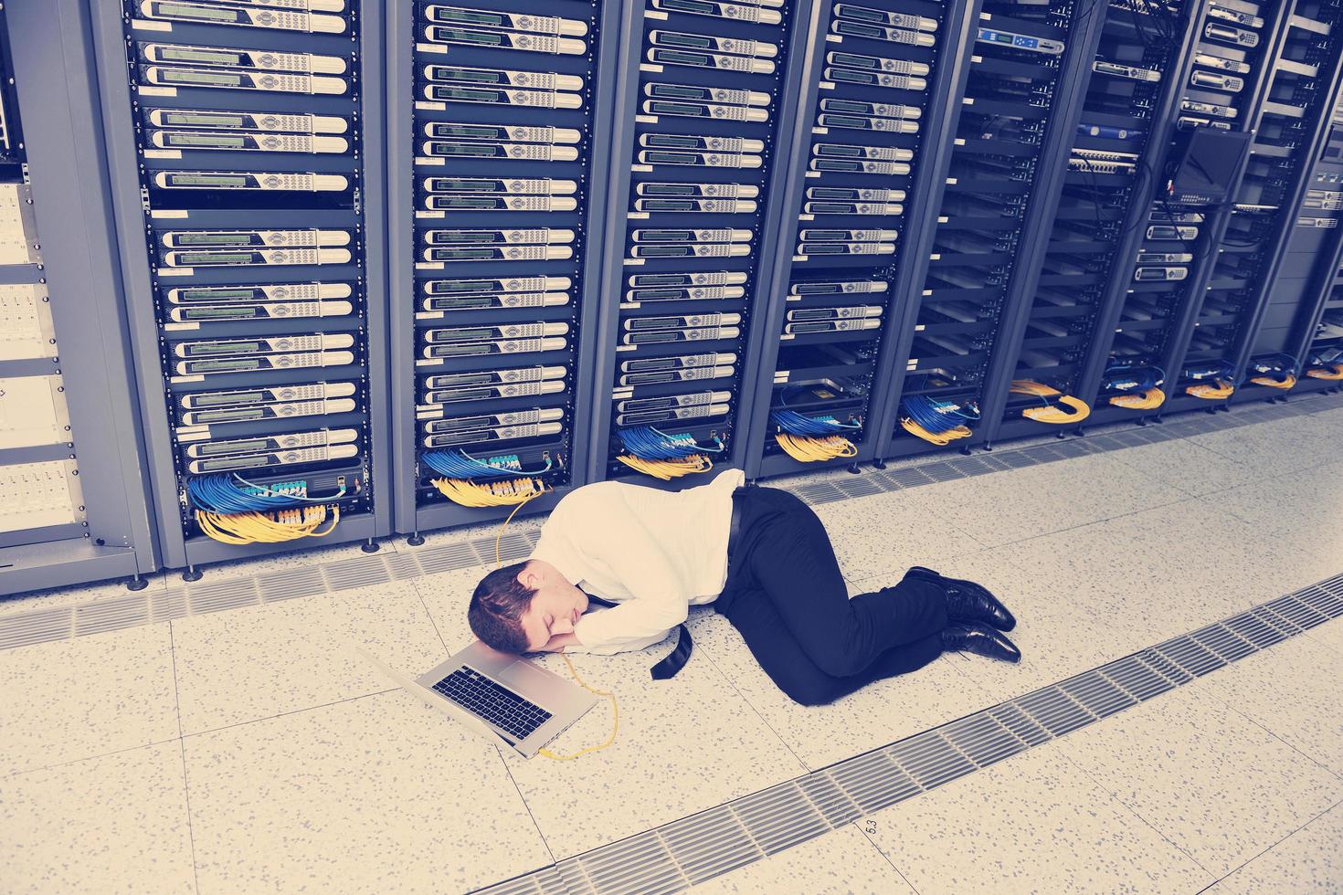 businessman with laptop in network server room photo