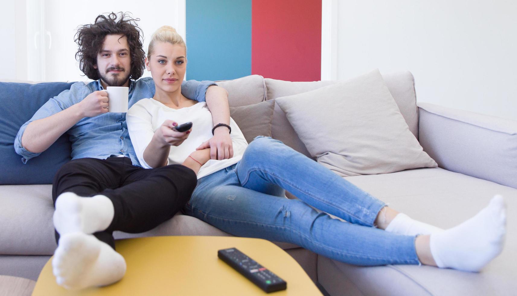 Young couple on the sofa watching television photo