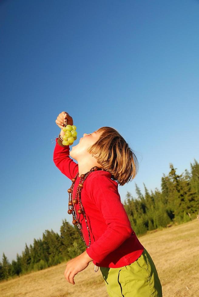 happy girl with grape outside photo