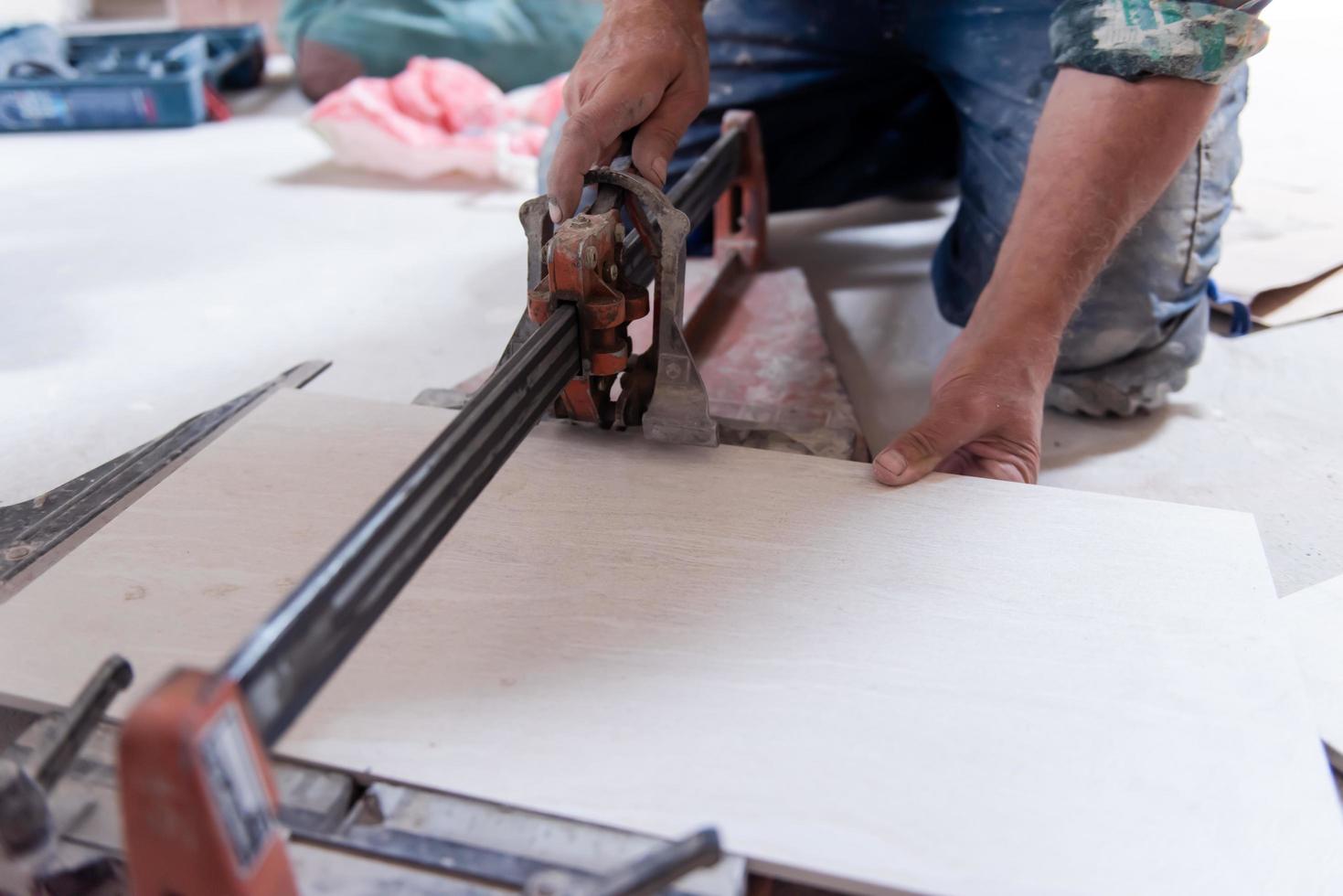 worker cutting the ceramic wood effect tiles photo